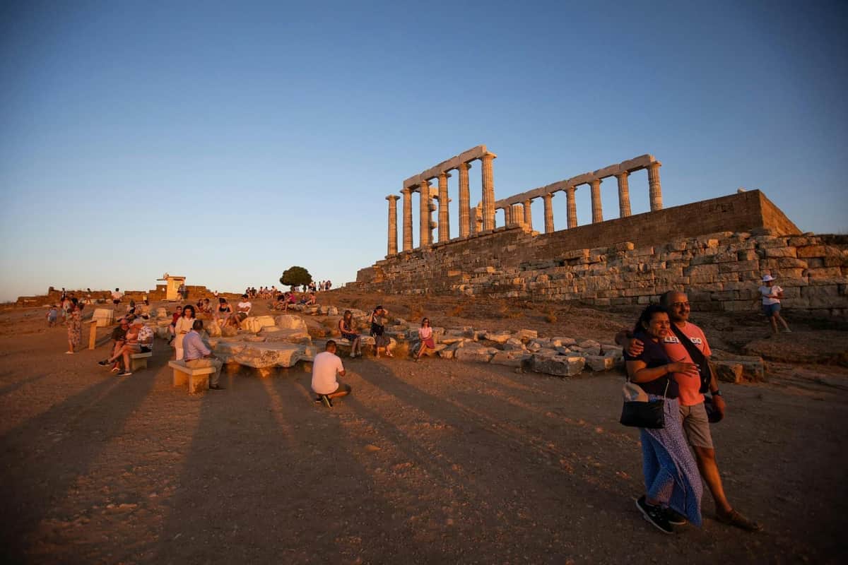 Cape Sounion & Temple of Poseidon: Sunset Tour from Athens Visitors at the Temple of Poseidon in Cape Sounion enjoying the golden sunset over the Aegean Sea.