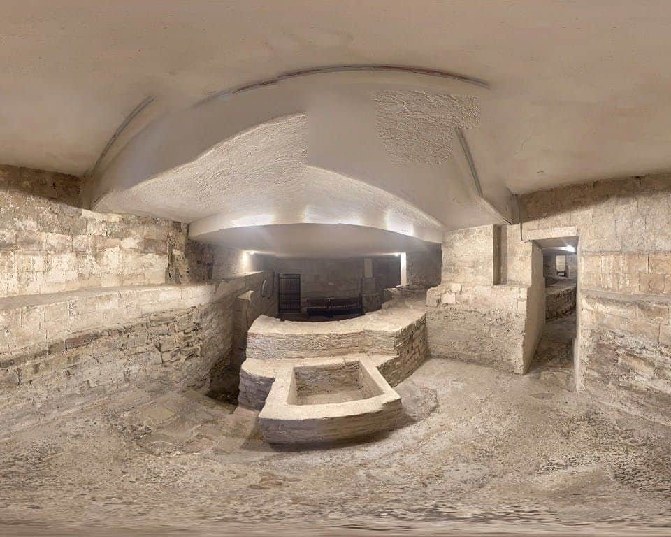 Termoli Underground: Entry Ticket An underground stone chamber with arched brick ceilings, wall niches, and passageways. Central rectangular pit with surrounding walls.