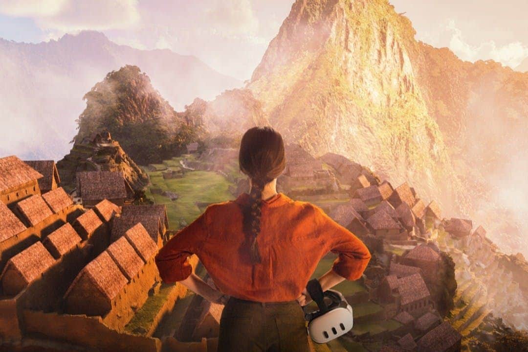Madrid: Machu Picchu - Journey to the Lost City Entry Ticket A person in an orange shirt with a braided ponytail stands overlooking the ancient structures of Machu Picchu at sunrise, holding a VR headset.