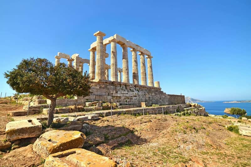Cape Sounion & Temple of Poseidon: Afternoon Tour from Athens Temple of Poseidon under blue sky at Cape Sounio, Greece
Ancient marble columns rise on a rocky hilltop above the Aegean Sea.