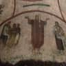 Priscilla Catacomb: Guided Tour Ancient mural showing a central figure in a red robe with raised arms, flanked by seated figures on both sides.